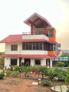 um grande edifício branco com um telhado vermelho em Mount View Villa em Lonavala