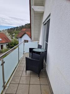 un balcón con 2 sillas y una mesa. en Ferienwohnung An der Karlskuppe, en Eisenach