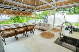 uma cozinha e sala de estar com uma mesa e um sofá em The Puncak Private Villa em Nusa Lembongan