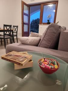 un bol de bonbons assis sur une table en verre devant un canapé dans l'établissement Dubrovnik Airport Apartment Pascal, à Močići