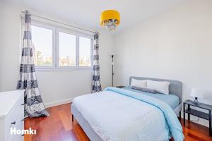 een witte slaapkamer met een bed en een raam bij Beau T3-résidence calme-proche Paris/La Défense in Suresnes