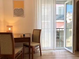 una sala da pranzo con tavolo e sedie e un balcone di Charming 1BR in Lagos Old Town - Near Beach & Cafés a Lagos