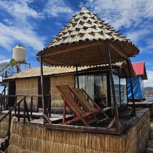 a hut with a straw roof and a bench at Q'OTA TAYPY LODGE in Puno