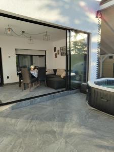 a living room with a tub and a table with chairs at Black&White House in Ocna-Mureşului