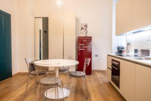 een keuken met een tafel en stoelen en een koelkast bij EVE Home Collection - City Center in Trieste