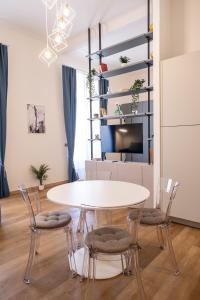 een eetkamer met een witte tafel en stoelen bij EVE Home Collection - City Center in Trieste