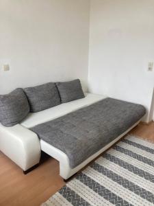 a white couch with gray pillows in a room at JUGENDSTIL VILLA LEOBEN GÖSS - nahe SPIELBERG FORMEL 1 in Leoben