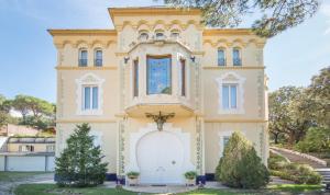 una gran casa amarilla con puerta blanca en Hotel Boutique Edelweiss La Garriga, en La Garriga