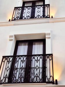 una ventana en un edificio blanco con barandillas negras en Old Town Villa, en Durrës