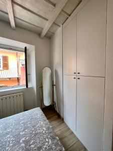 - une chambre avec une armoire blanche et un réfrigérateur dans l'établissement CASA SUL LAGO, à Arona