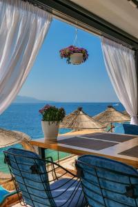 una mesa y sillas con vistas al océano en Fabeno Villa, en Sarandë