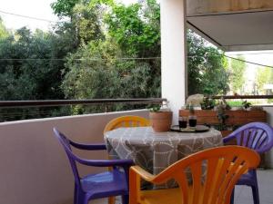 une table et des chaises assises sur un balcon avec une table et des chaises dans l'établissement Kalamata's Handmade Apartment, à Kalamata