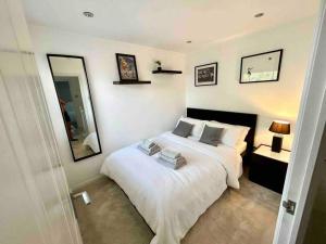 una camera con letto bianco e specchio di Home in Southsea, Portsmouth, Close to the Sea a Portsmouth