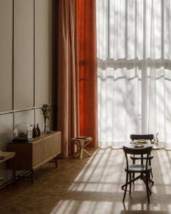 een kamer met een tafel en stoelen en een groot raam bij kleiner Löwe – Stadthotel Bregenz in Bregenz