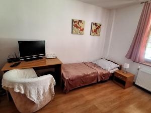 una camera da letto con scrivania e letto con computer di Penzión Villa Agnes a Smolenice