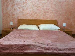 una camera con un letto con una coperta rosa e due lampade di Penzión Villa Agnes a Smolenice