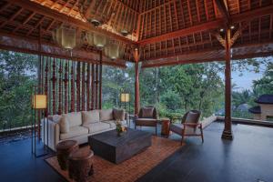 Sanna Ubud A Pramana Experience في أوبود: غرفة معيشة مع أريكة وطاولة وكراسي