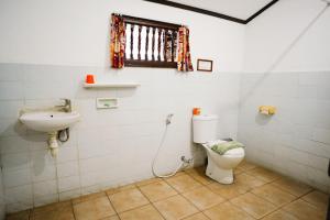 La salle de bains est pourvue de toilettes et d'un lavabo. dans l'établissement Temple Cafe & Cottages, à Candidasa