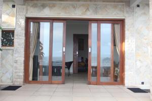 - un bâtiment avec des portes en verre offrant une vue sur l'océan dans l'établissement Temple Cafe & Cottages, à Candidasa