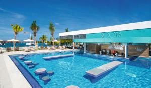 una piscina in un resort con sedie e ombrelloni di Riu Montego Bay - Adults Only - All Inclusive a Montego Bay