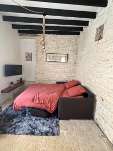 um quarto com uma cama numa parede de tijolos em La maison de pierres em Chablis