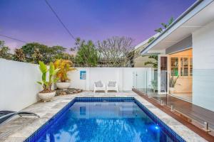 Gold Coast-Miami Mid-Century Beach Home With Pool في غولد كوست: مسبح في الحديقة الخلفية للمنزل