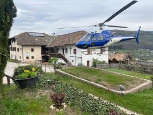 a blue helicopter is flying over a house at Arzenhof, Baron Di Pauli in Caldaro