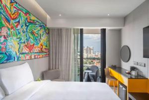 um quarto de hotel com uma cama e um quadro na parede em Hotel Mi Rochor em Singapura