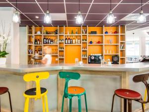 a bar with colorful stools in a restaurant at Ibis Styles Sallanches Pays du Mont-Blanc in Sallanches