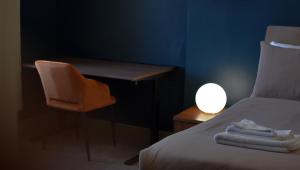 a room with a bed and a desk with a lamp at Nomi Rooms & Restaurant in Bangor