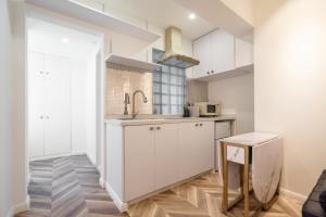 a kitchen with white cabinets and a sink at Shanghai Hills & Serendipity MCM Near Line1 & Line2 People's Square in Shanghai