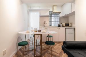 a kitchen with a table and some green chairs at Shanghai Hills & Serendipity MCM Near Line1 & Line2 People's Square in Shanghai