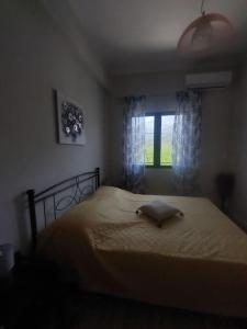 a bedroom with a bed with a pillow and a window at ΛΕΥΚΙΑΣ. in Pirgos Dhirou