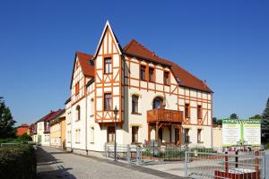 ein großes orangefarbenes und weißes Gebäude auf einer Straße in der Unterkunft Ferienwohnung Auszeit am Kurpark - Balkon - ruhige Lage- Parkplatz - WLAN in Bad Berka