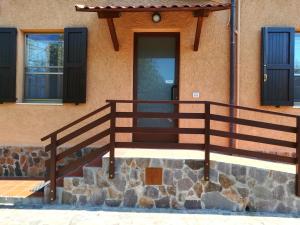 une maison avec une balustrade en bois et une porte dans l'établissement Nuraghe Bianco, à Santa Maria la Palma