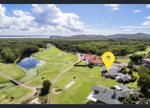 eine Luftansicht eines Golfplatzes mit gelbem Schild in der Unterkunft Perfect weekend getaway plus golf at your doorstep in Salamander Bay