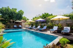 einen Pool mit Stühlen und Sonnenschirmen in der Unterkunft The Parnas in Nusa Lembongan