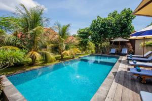 einen Pool in einem Resort mit Stühlen und Bäumen in der Unterkunft The Parnas in Nusa Lembongan