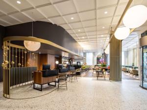 um lobby de um hotel com cadeiras e mesas em Pullman Stuttgart Fontana em Estugarda