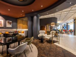 um lobby de um hotel com cadeiras e mesas em Pullman Stuttgart Fontana em Estugarda