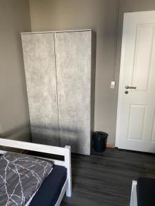 a bedroom with a metal cabinet next to a bed at M&R Hostel in Rostock