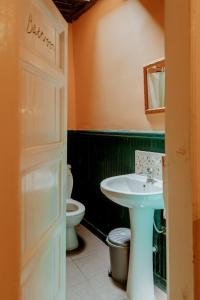 uma casa de banho com um lavatório e um WC em Berat Backpackers Hostel em Berati