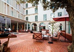 een binnenplaats met stoelen en tafels en een gebouw bij Convent Square Lisbon, Vignette Collection by IHG in Lissabon