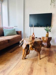 a living room with a wooden table and a couch at Bos Water Huisje Veluwemeer in Biddinghuizen