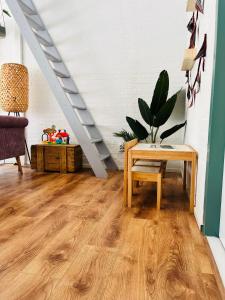 a living room with a table and a staircase at Bos Water Huisje Veluwemeer in Biddinghuizen