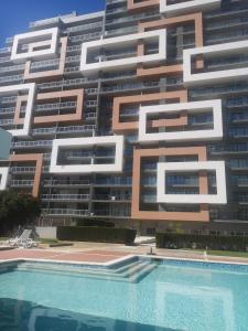 um grande edifício com uma piscina em frente em Rocha T Apartments em Portimão