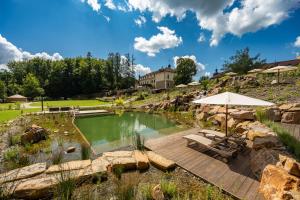 einen Pool mit Terrasse und Sonnenschirm in der Unterkunft Wellness & spa hotel Augustiniánský dům in Luhačovice