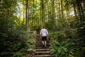 Ein Mann, der im Wald die Treppe hinuntergeht in der Unterkunft Wellness & spa hotel Augustiniánský dům in Luhačovice