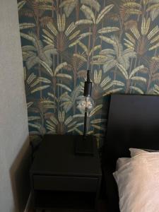 a lamp on a night stand next to a bed at 4 tot 8 persoons huisje - Veluwemeer - Biddinghuizen - Harderwijk - Elburg in Biddinghuizen