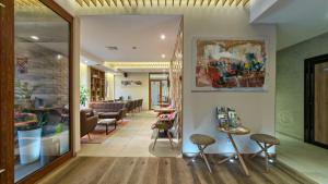 a lobby with a waiting area with chairs and tables at Hotel Mons in Zlatibor